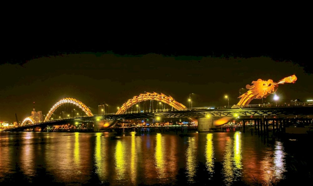 The giant steel dragon of Dragon Bridge breathes fire in bursts of bright flames